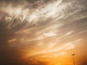 An enchanting sky with cirrus clouds and a golden sunset casting a warm glow.